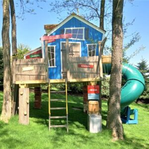 The Crazy Clubhouse is a colorful blue elevated children's playhouse with a wacky cartoonish design and a green spiral slide. It includes a ladder for easy access. Ideal for your backyard adventures!