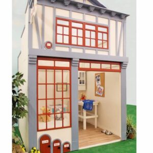 The Animal Hospital playhouse featuring large red-framed windows, a counter inside, and a teddy bear seated. Adjacent to the structure is a small pet door.