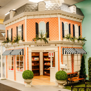 A corner market playhouse stands proudly as a centerpiece of a beautiful indoor children's play cafe.