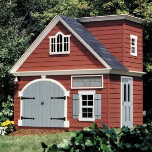 A red playhouse designed like a small fire station with double doors in the front, windows, and a custom named sign, set in a garden area with greenery around.