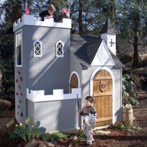Children play and pretend with a backyard castle playhouse which includes a climbing wall and lookout.