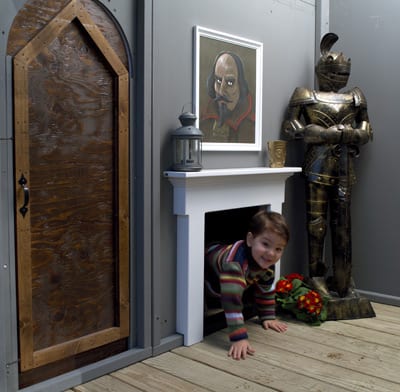 Child crawls thru the hidden tunnel found in the fireplace of child's backyard castle play house.