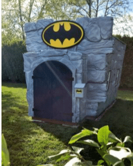 Custom Batman, "Bat Cave" themed children's playhouse with faux stone exterior, bat signal, and large barn-style doors.