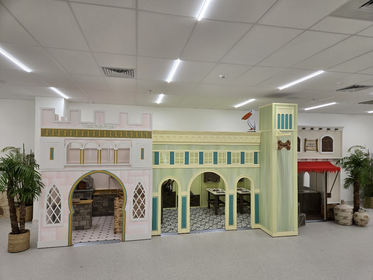 A group of custom play houses, themed as a biblical town including a café, animal hospital, and market.