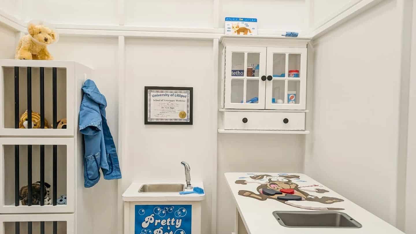 Custom child sized furniture, themed as a miniature animal hospital. this includes an exam table, a washing station, and pretend kennels.